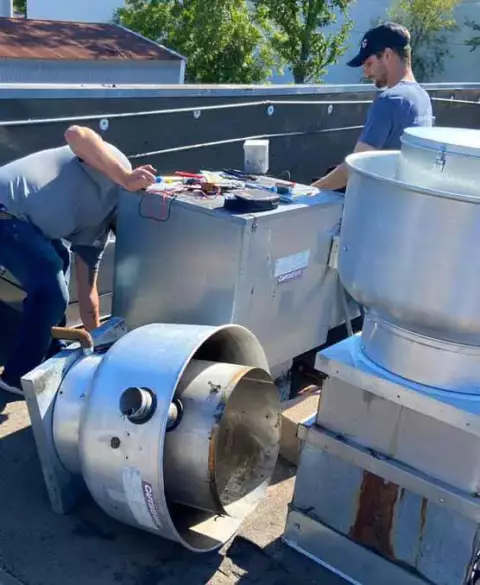 Skilled technicians working on the installation of a commercial HVAC unit